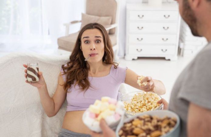 donna sul divano che mangia pop corn